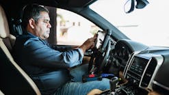 Technician with scan tool in car